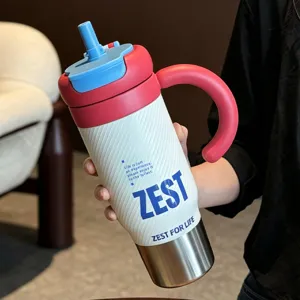 Insulated stainless steel travel tumbler with handle and straw lid, textured body, detail view.