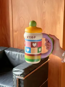 Detailed shot of large novelty water bottle with colorful heart pattern and purple handle.
