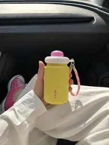Detailed view of a mini portable stainless steel thermos cup with cute cap and lanyard in car.