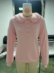 Pink ribbed knit sweater detail, cute ruffled collar and detailed front button close-up.