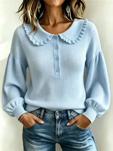 Close-up of light blue ribbed knit sweater featuring a chic ruffled collar and button placket.