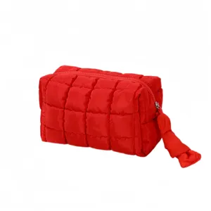 Detailweergave van de rode gewatteerde cosmetische tas met vierkant patroon en handige rits.