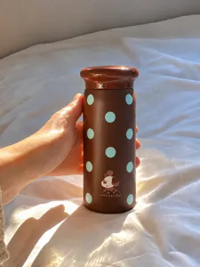 Pequeña botella térmica de bolsillo con lunares marrones y un diseño adorable de perrito.