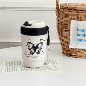 Portable insulated coffee mug with butterfly print and hand strap for daily office use.