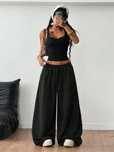 Casual streetwear two-piece outfit with slim black crop top and wide-leg sweatpants detail.