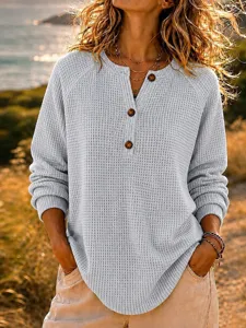 Detail view of women waffle knit henley long sleeve top with buttons in casual loose fit.