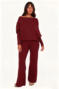 Burgundy knit two piece set featuring off shoulder sweater and flared pants detail.