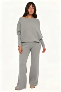 Knitwear detail showing the soft slanted shoulder sweater and flare pants in elegant grey tone.