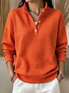 Orange waffle knit long sleeve henley shirt detail view, showing texture and buttons.