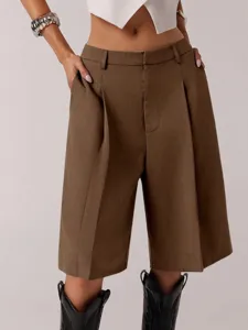 Detail of women's brown pleated casual shorts, loose fit tailored style for summer.