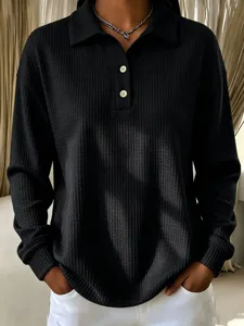 Black waffle knit polo long-sleeve top featuring button closure and classic lapel collar.