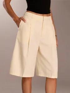 Detail view of women high waist pleated tailored shorts in elegant off white color.