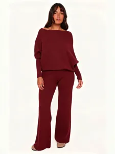 Burgundy knitted two piece set featuring an elegant off-shoulder sweater and flared pants.