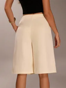 Detail view of casual beige tailored bermuda shorts for women, high waist solid color design.