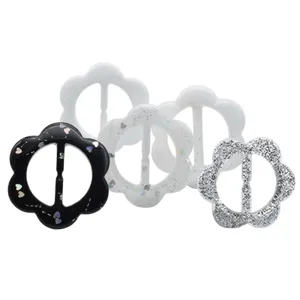 Close up of exquisite floral resin clothing buckles with glitter and heart details for apparel.