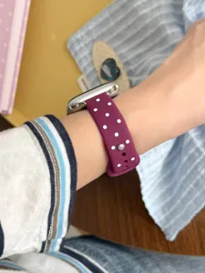 Vista detallada de la correa de reloj de silicona de lunares usada en la muñeca, suave y cómoda.