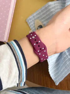 Primer plano detallado de una correa de reloj inteligente de silicona morada con lunares.