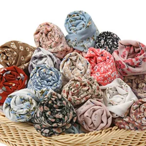 Rouleaux de tissu à fleurs dans un panier, vue détaillée de pièces textiles colorées assorties.