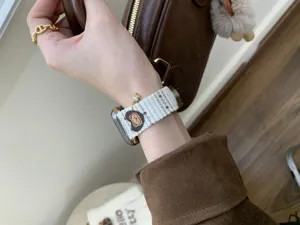 Corduroy Apple Watch strap detail featuring cute bear heart charm and sparkling rhinestone star.