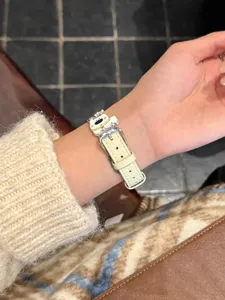 Lederuhrarmband Detail mit süßem Hundemotiv und Metallschließe am Handgelenk.
