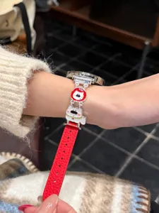 Nahaufnahme des roten Lederarmbands mit einem niedlichen Metallwelpen-Anhänger im Detail.