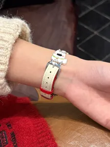 Detailansicht des niedlichen welpen lederuhrenarmbands mit metallschnalle am handgelenk.