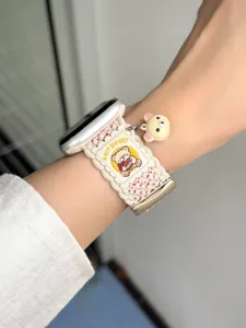Gedetailleerde close-up van een geweven nylon horlogeband met schattige berenbedel en sluiting.