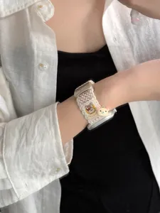 Gedetailleerde close-up van de gevlochten nylon horlogeband met een schattig berenontwerp.