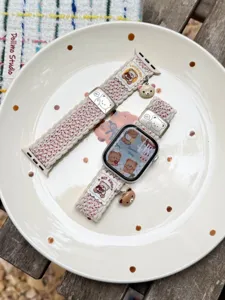 Detailopname van de schattige nylon gevlochten Apple Watch band met leuke beren hangertjes.