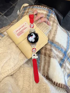 Detaillierte Nahaufnahme des roten Lederarmbands mit Hundemotiv auf kariertem Untergrund.
