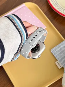 Detalle de correa de reloj de silicona de lunares, banda gris suave con puntos blancos para reloj.