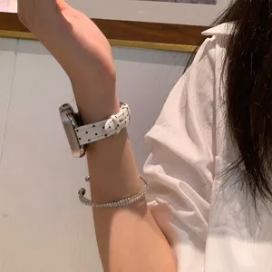 Detailopname van een wit lederen horlogebandje met stippen, compatibel met apple watch, stijlvol.