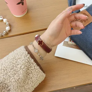 Detailed view of the burgundy genuine leather clover replacement strap worn on wrist for smart bands.