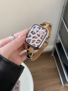 Primo piano del cinturino per orologio in cavallino leopardato con borchie a stella.