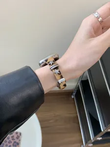 Primo piano del cinturino per orologio in cavallino leopardato con stelle in metallo Apple.