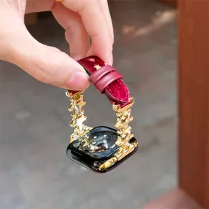Gros plan détail d'un bracelet de montre Apple en peluche rouge et métal étoile dorée.