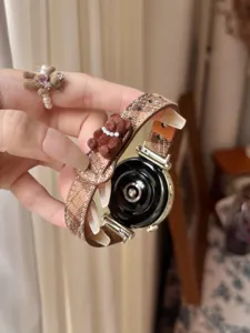 Brown plaid watch strap with cute fuzzy bear charm for smart watch detail view display.