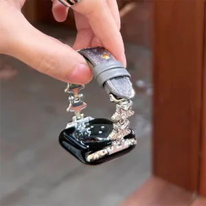 Gros plan sur les détails du bracelet montre en métal étoile et peluche pour Apple Watch.