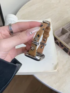 Dettaglio cinturino orologio stella in pelle, elegante accessorio con stampa leopardo.