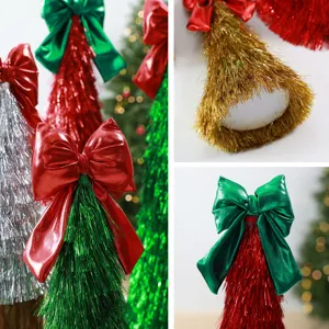 Detailaufnahme von Lametta-Weihnachtsbaum-Ornamenten mit metallischen Schleifen, festliche Dekoration
