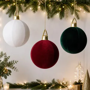 Nahaufnahme von hängenden Samt-Weihnachtskugeln in Weiß, Rot und Dunkelgrün für die Feiertage.