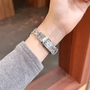 Vue détaillée du bracelet de montre en velours gris élégant avec breloques étoiles pour Apple Watch.