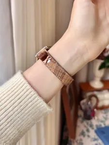 Plaid watch strap with cute little bear and bow decoration, comfortable daily wear detail.