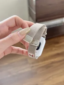 Detailopname van de geweven nylon smartwatch-band met metalen gesp en schattig accent.