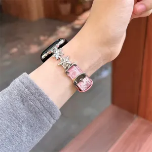 Vue détaillée du bracelet de montre en velours rose et étoiles en métal pour Apple Watch.