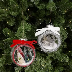 Transparent acrylic Christmas ball ornament featuring detailed winter scenery and miniature trees inside.