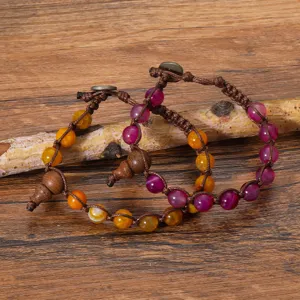 Détail de bracelet tressé en agate naturelle et œil de tigre avec perle en bois.