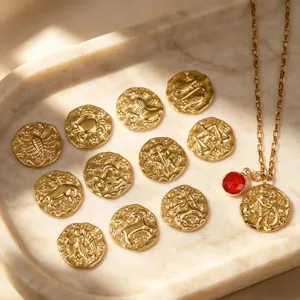 Vue détaillée de douze pendentifs ronds en métal du zodiaque sur un plateau de marbre.