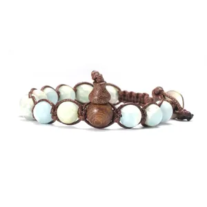 Détail de bracelet en pierre naturelle et gourde en bois, beau cordon marron tressé.
