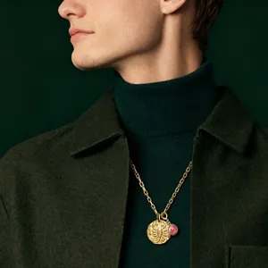 Gros plan détail du collier pendentif zodiaque scorpion en or avec pierre précieuse sur modèle.